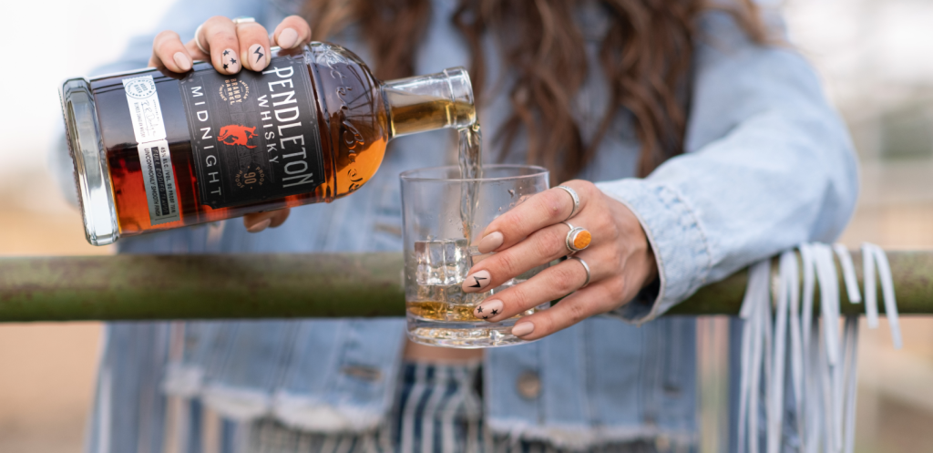 Cowgirl pouring Pendleton Whisky Midnight